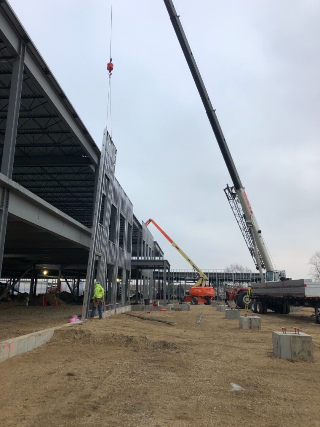 Prefabricated CFS wall panels installing on a steel-frame commercial building.