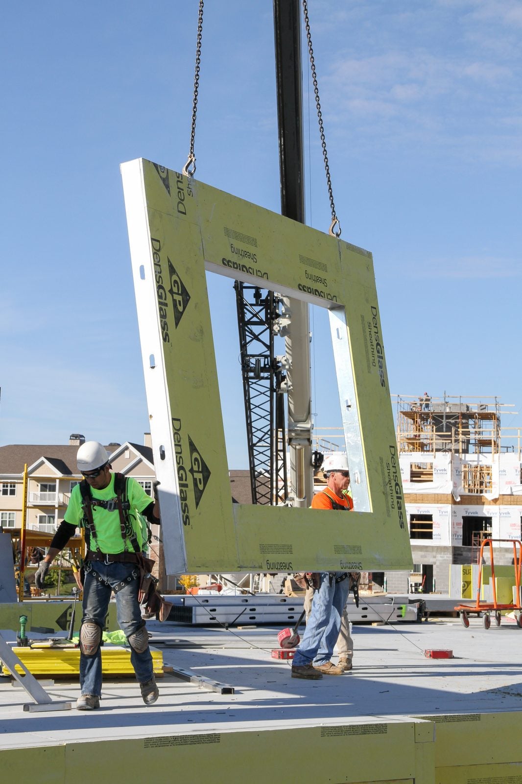 Prefabricated CFS wall panel with DensGlass sheathing being set by crane.